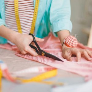 Talleres textiles, mujer cortando tela con tijeras
